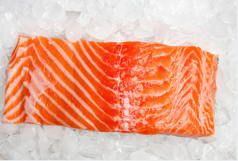 Atlantic Salmon fillet, 8 oz portion, displayed on a bed of ice for freshness — premium cut with rich color.