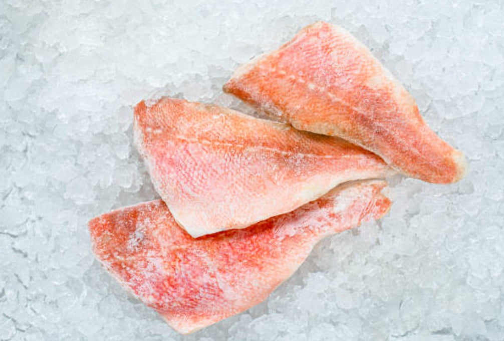 Wild-caught Red Snapper fillets, skin-on, displayed on ice to showcase freshness — vibrant pink flesh and premium quality seafood