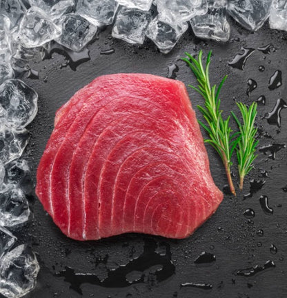 Sushi-grade tuna steaks, 8 oz fillets, displayed on a bed of ice — rich red color, premium cut, ready for cooking or sashimi